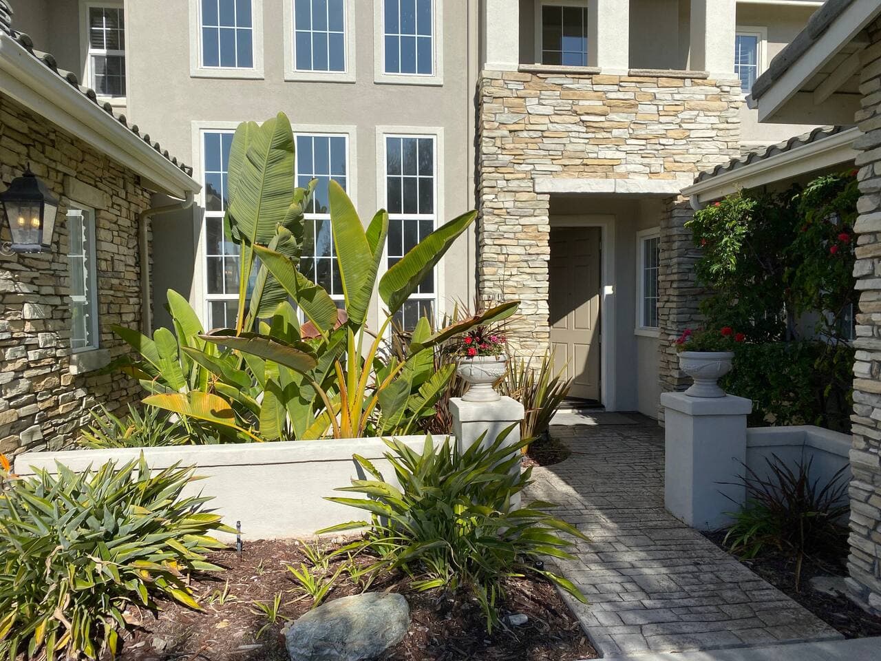 Open entry way to front door with two sconces to illuminate the way.